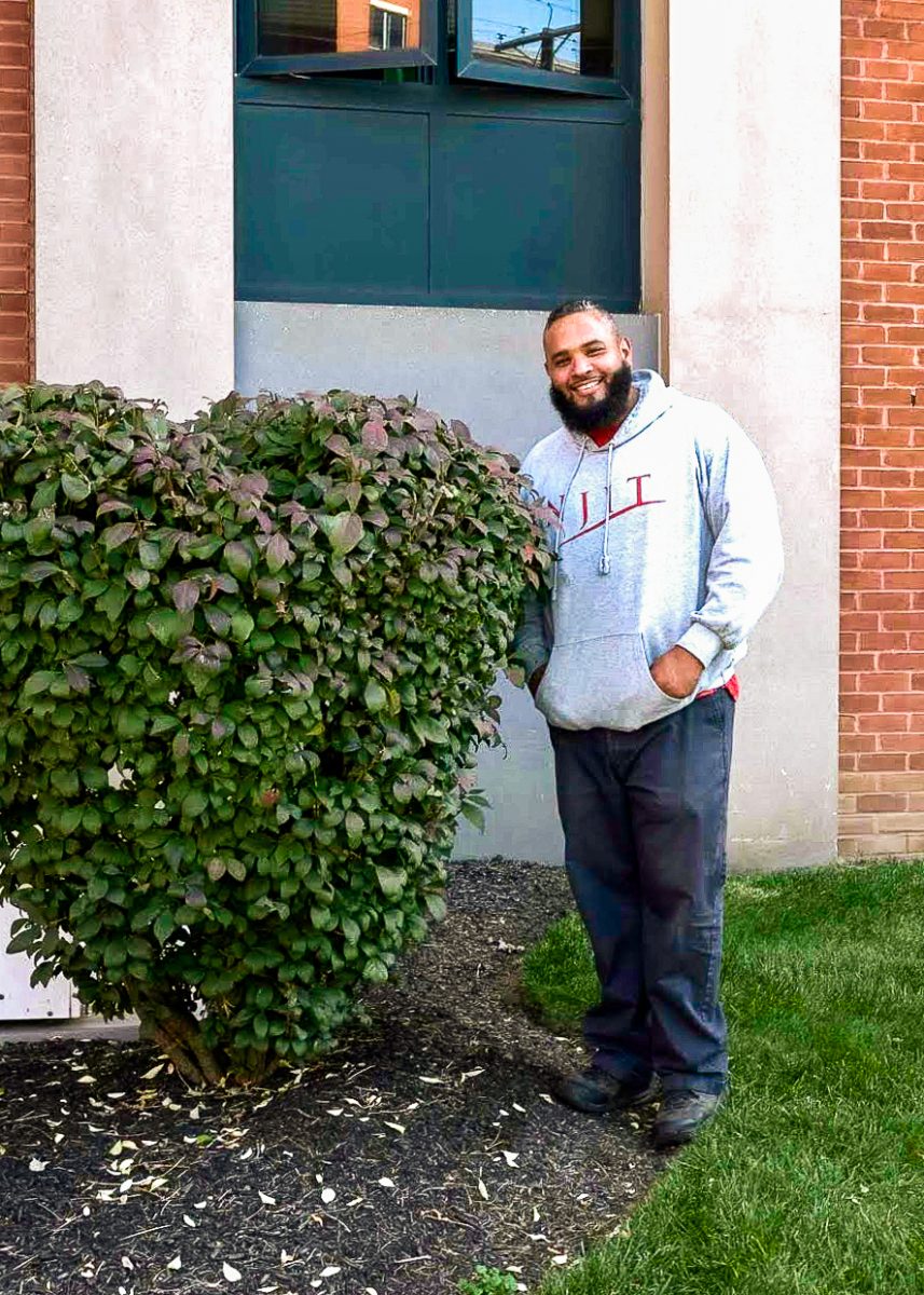 Groundskeeper Omar Garcia stands next to a heart-shaped bush of his own creation on Summit Street.