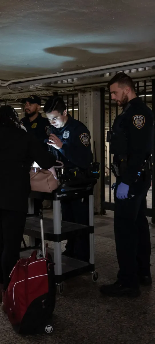 Police officers check bags at the subway station | Photo by Adam Gray | The New York Times